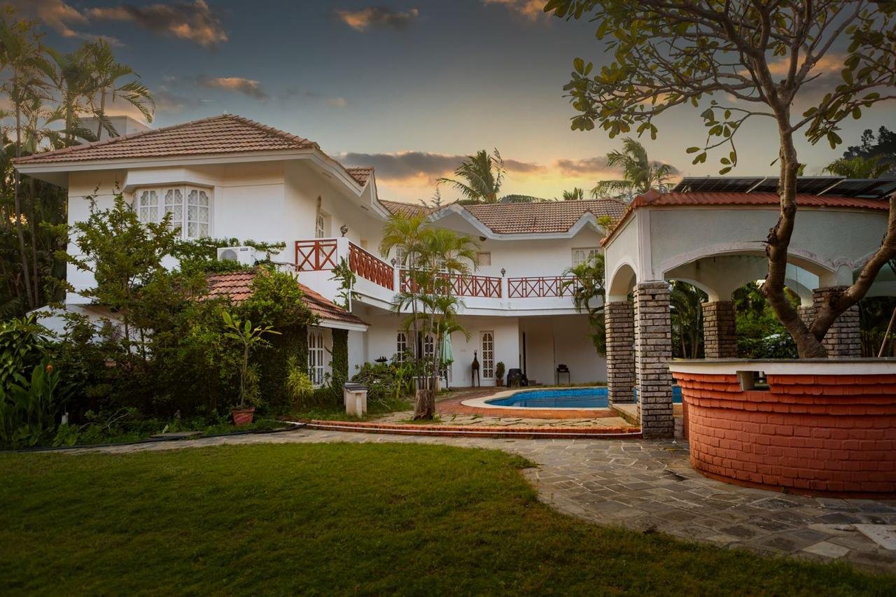 A Youkoso villa at dusk, with a private pool, gardens and courtyard